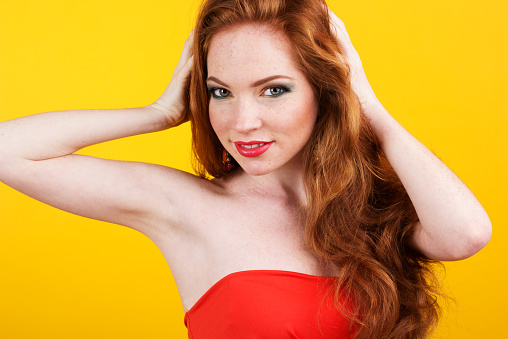Portrait of beautiful redheaded girl with fashion colorful makeup in studio 