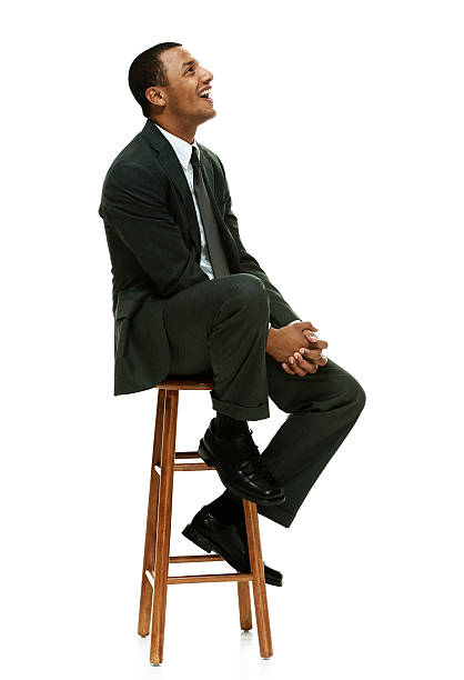 istock Smiling businessman on stool and looking away 469328316