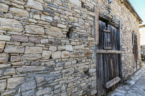 Stone wall with rustic wooden door in Lefkara village, Cyprus.