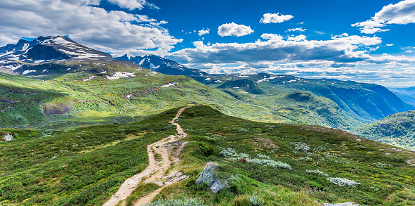 Panoramic view of the landscape of Jotunheiman National Park in the Oppland County. With a hiking trail leading out onto the expansive terrain for hikers and adventure seekers of Norway!