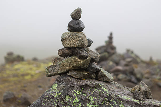 These stack of rocks (known as cairns) refer to the traditional way of marking safe routes across the mountains in Norway, or as a way of announcing that a peak has been conquered.