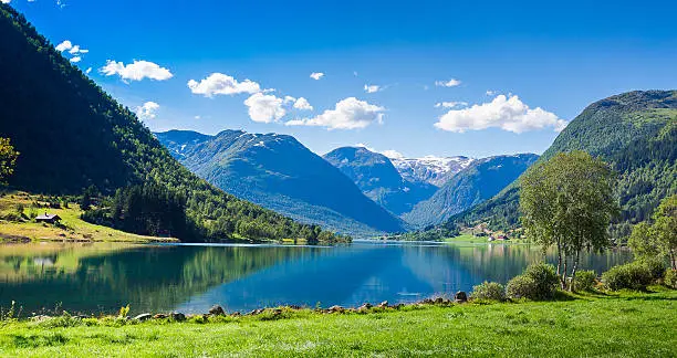 A Fjord of rich blue against a calm sky in a valley of Norway's Sogndal County.