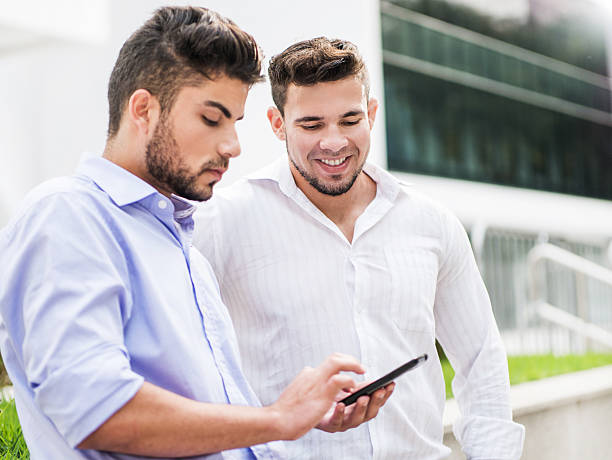 istock Hispanic businessmen using smart phone outdoors. 469338292