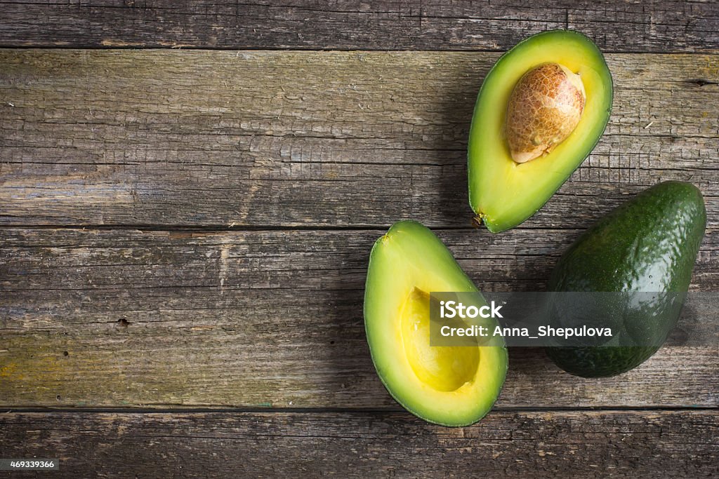 food background with fresh organic avocado on  old wooden table food background with fresh organic avocado on  old wooden table, top view, copy space Avocado Stock Photo