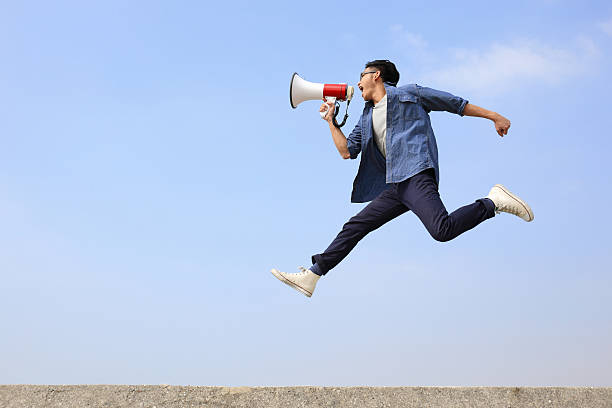 istock man jump and shout megaphone 469344250