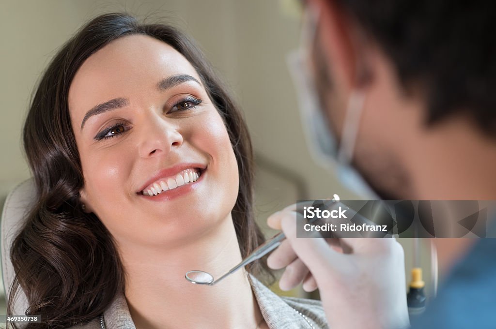 A woman receiving dental treatment from a hygienist Closeup of dentist visiting a patient in clinic 20-29 Years Stock Photo