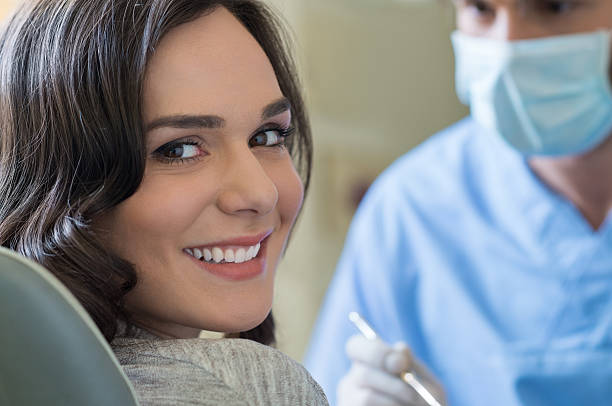 lächelnde frau beim zahnarzt - dentist office dental hygiene dentists chair human teeth stock-fotos und bilder