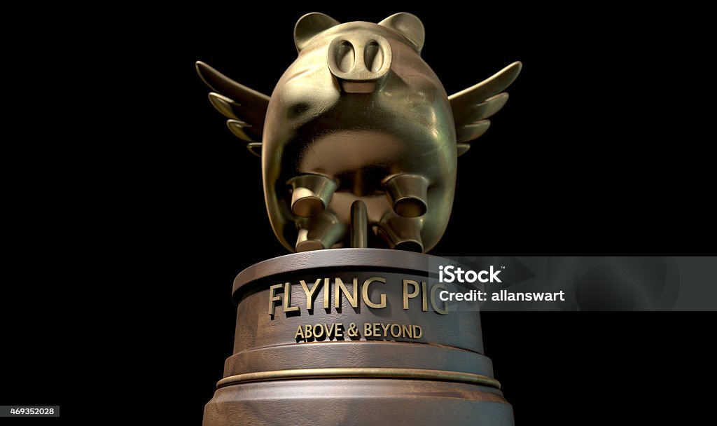 Flying Pig Trophy Award A gold trophy of a mythical flying pig on top of a wooden base and a description which reads above and beyond on an isolated dark studio background When Pigs Fly Stock Photo