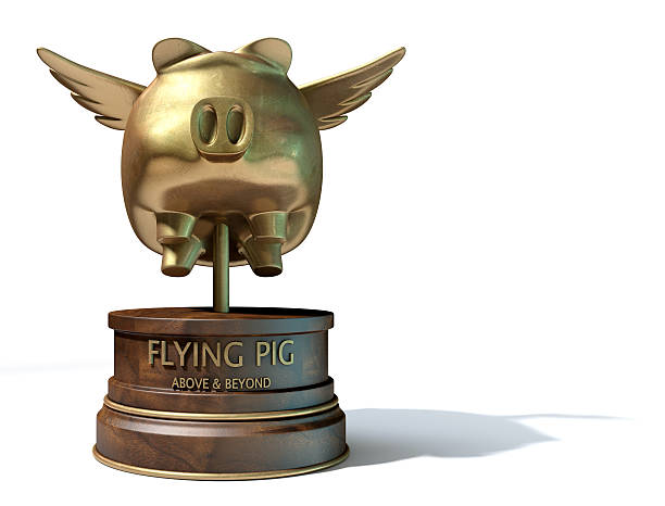 A gold trophy of a mythical flying pig on top of a wooden base and a description which reads above and beyond on an isolated white studio background