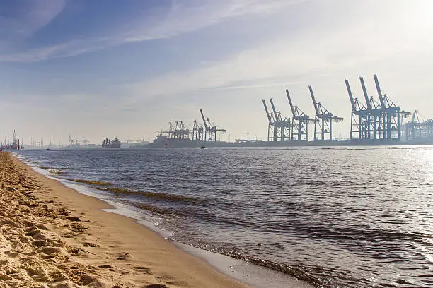 Container bridges on the Elbe in the Port of Hamburg in the morning hours shortly after sunrise.