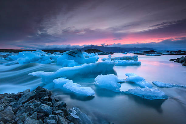 icebergs плавающая в ёкюльсаурлоун glacier озеро на закате - mountain reflection non urban scene moody sky стоковые фото и изображения