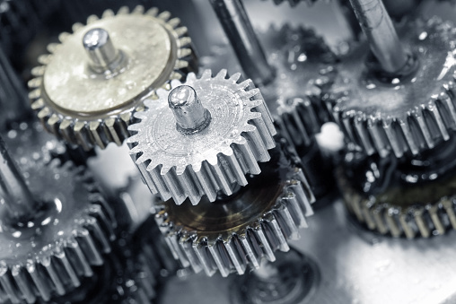 Macro picture of small gear wheels inside a machine. A gear or cogwheel is a rotating machine part having cut teeth, or cogs, which mesh with another toothed part to transmit torque, in most cases with teeth on the one gear being of identical shape, and often also with that shape on the other gear. Geared devices can change the speed, torque, and direction of a power source. 