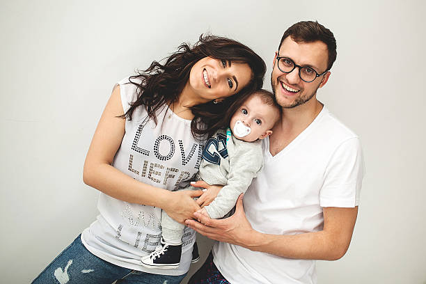hipster pai, mãe segurando um lindo bebê menino sobre branco backgrou - cheeper imagens e fotografias de stock