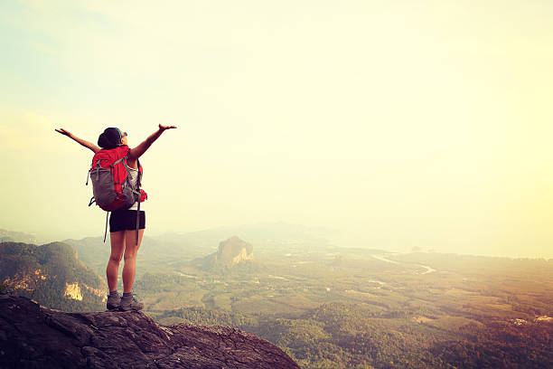 istock cheering hiking woman on mountain peak 469376482