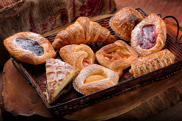 ассортимент французских & плюшки on a wicker basket - basket bread breakfast close up стоковые фото и изображения