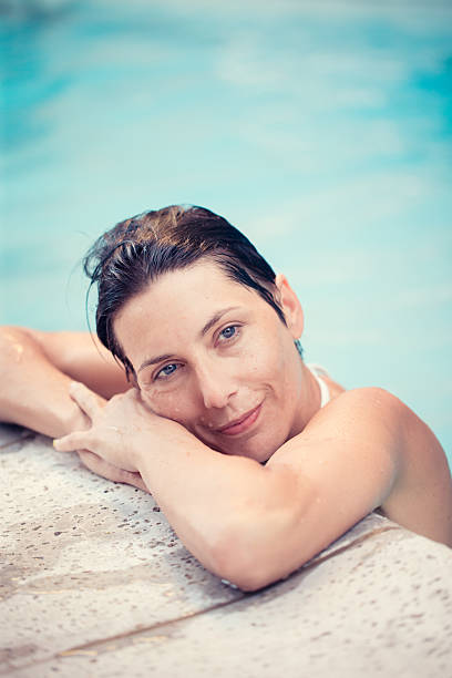 istock Woman relaxing at poolside 469382688