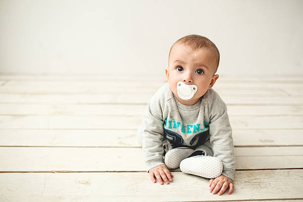 um ano de idade cute bebê menino sentado no chão de madeira - cheeper imagens e fotografias de stock