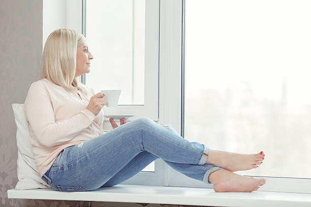 istock Woman sits on the windowsill 469392522