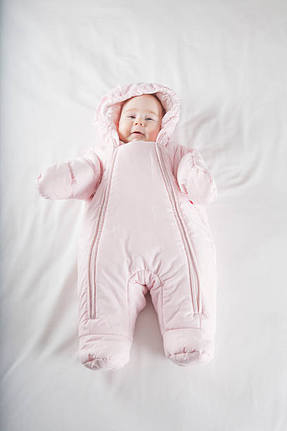 istock pink snowsuit baby on bed 469397382