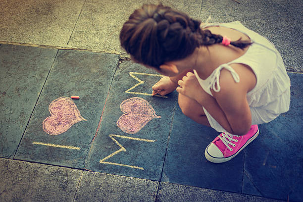 vista aérea de la mujer escribiendo en la acera - little girls sidewalk child chalk fotografías e imágenes de stock