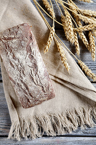istock Whole Loaf of Bread with spikelets wheat on a sacking 469412858