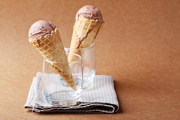 пара шоколадных вкус мороженое конуса в бокал - melting ice cream cone chocolate frozen стоковые фото и изображения