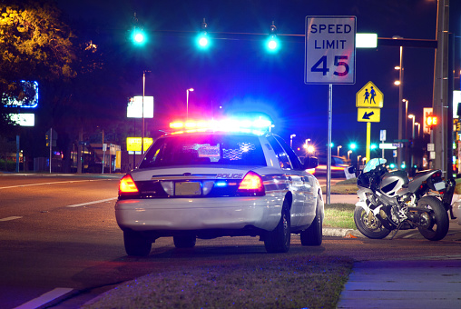 Motorcycle pulled over at night for a police traffic stop.