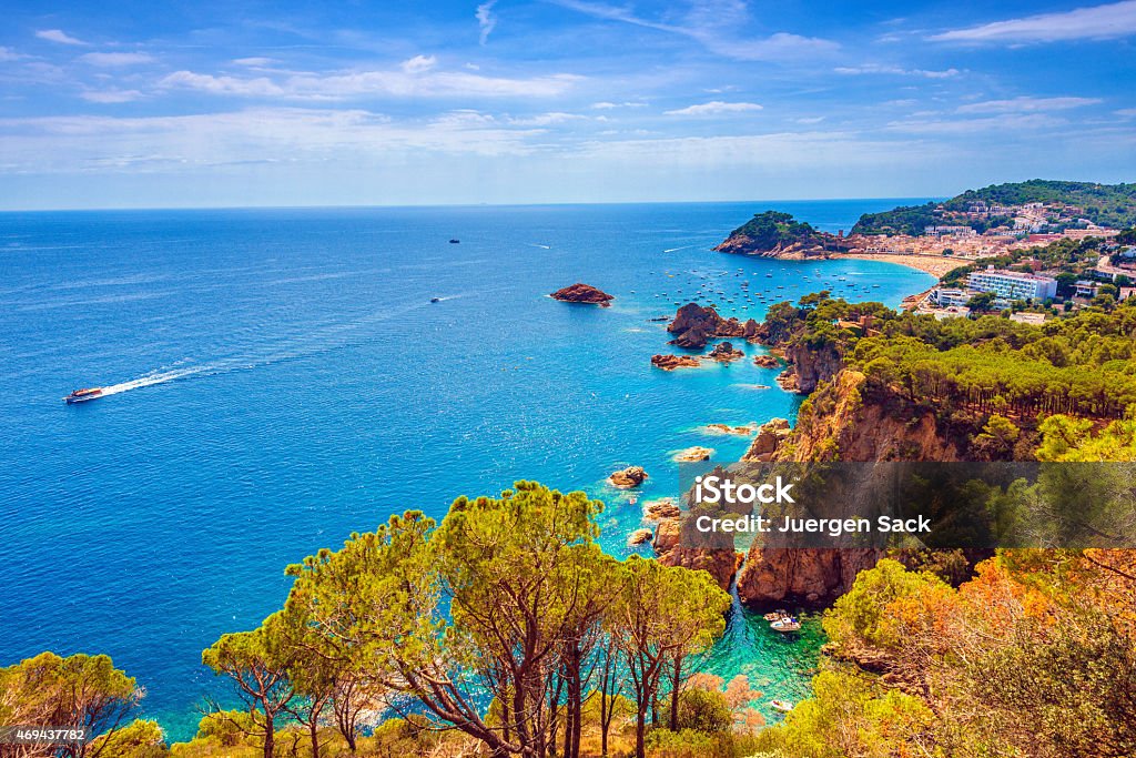 Beautiful Costa Brava Coastline and Tossa Del Mar Elevated view over the coastline, boats and cityscape of Tossa del Mar with the walled-in a fortified medieval Old Town on  a beautiful August summer day. Gerona Province Stock Photo