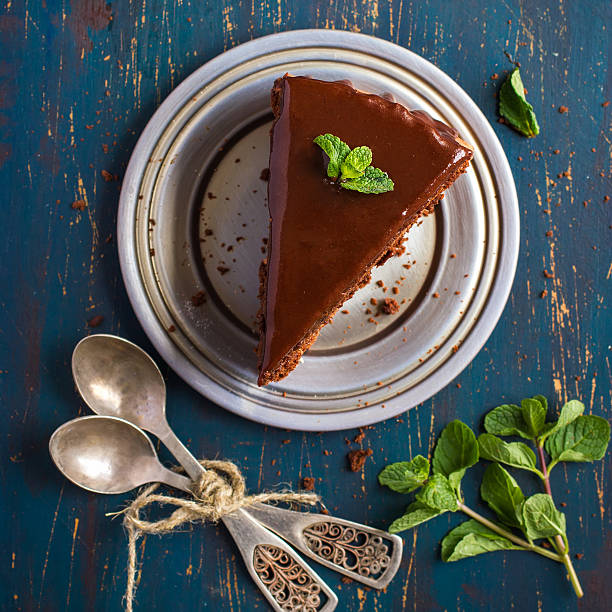 istock piece of chocolate cake with mint leaves, top view 469440534
