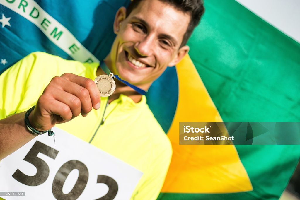 Athlete showing medals Athlete showing medals. Brazilian flag in the background 20-24 Years Stock Photo