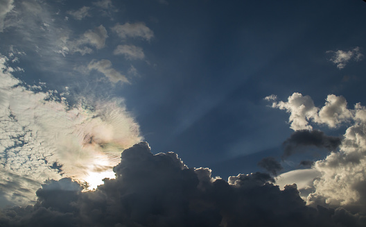 Clouds illuminated highlights the hidden sun, sky in the rays