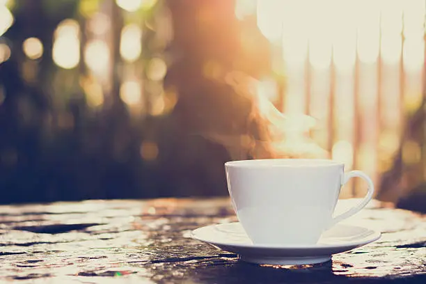 Photo of Cup of coffee on old wood table - vintage tone