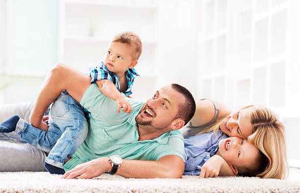 istock Playful family having fun on carpet at home. 469452084