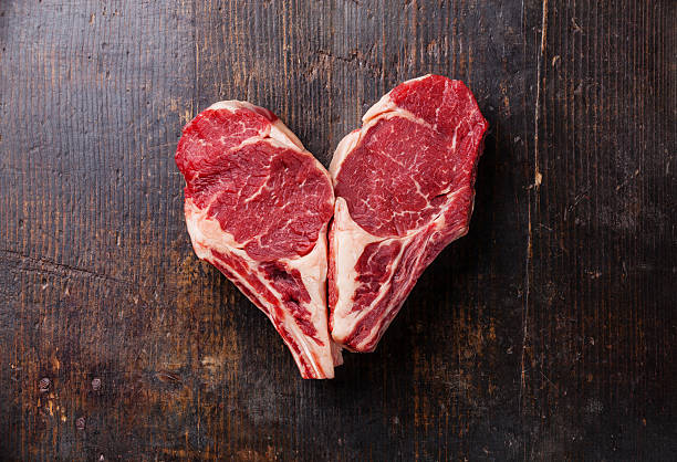 сердце формы необработанными мясо стейк ribeye - meat raw beef love стоковые фото и изображения