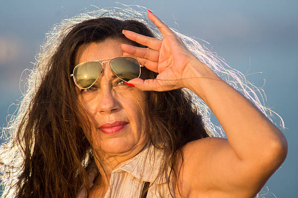 istock Female possing with binoculars and sunglasses. Ocean in background 469455290