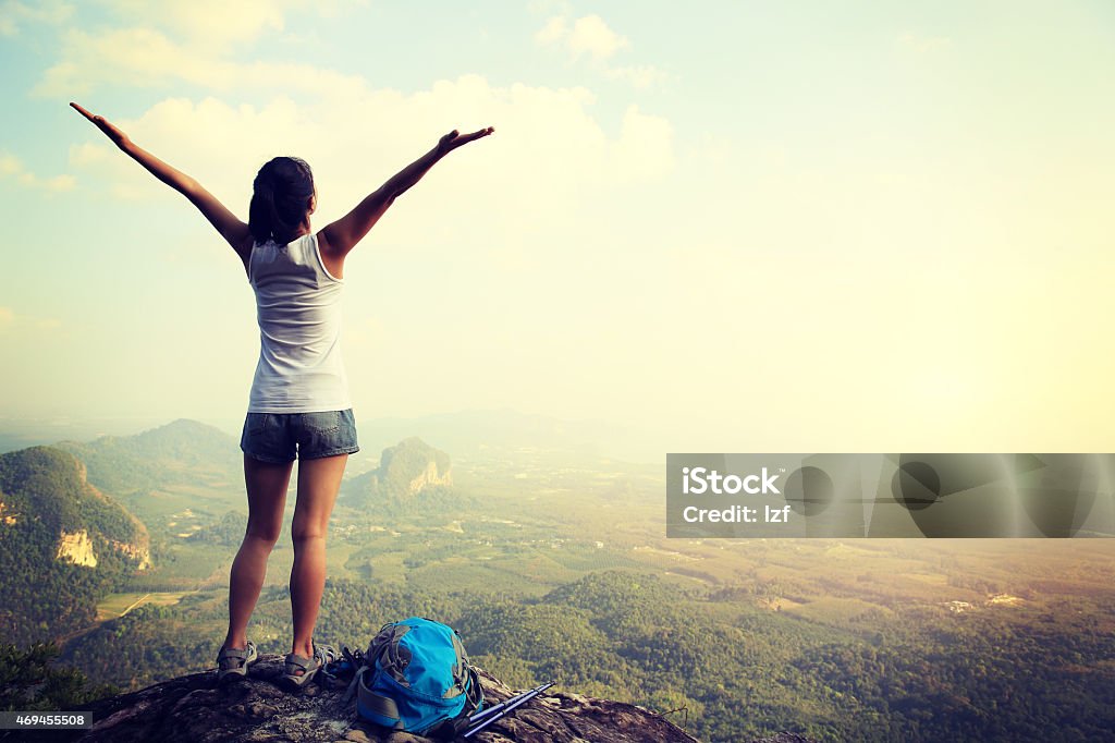 cheering hiking woman on mountain peak cheering hiking woman open arms on mountain peak Adult Stock Photo