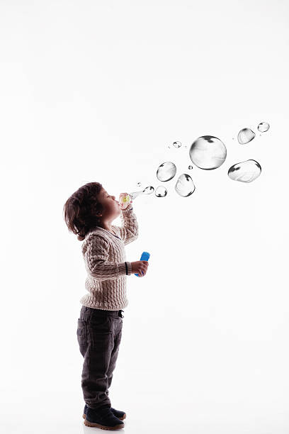 cuatro años de edad preescolar niño jugando con burbujas de jabón - bubble child bubble wand blowing fotografías e imágenes de stock