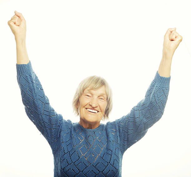 istock cheerful senior woman gesturing victory 469465724