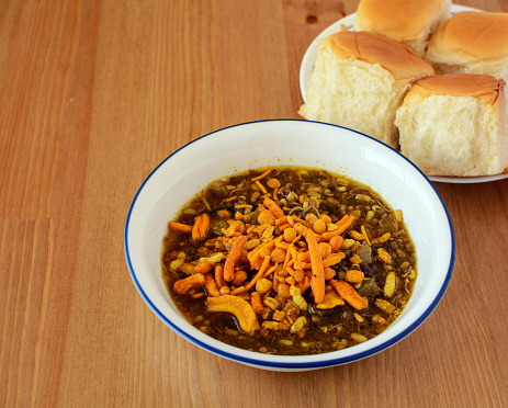 Misal paav is a famous spicy breakfast and snack item in Maharashtra, India. It is a mixture of lentil curry and farsan, served with paav bread.