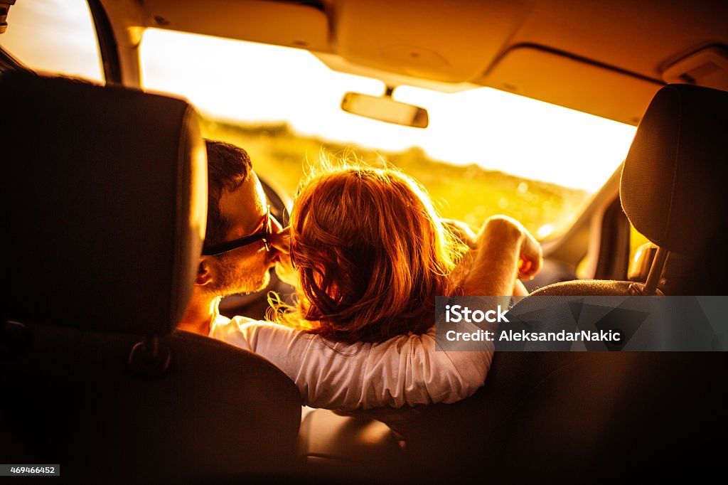 Kissing on the road Photo of young couple kissing in their car on the road 20-29 Years Stock Photo