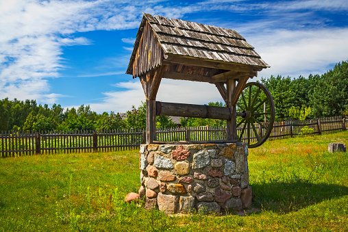 Old rustic stone well with wood shingle roof, Wielkopolska, Poland