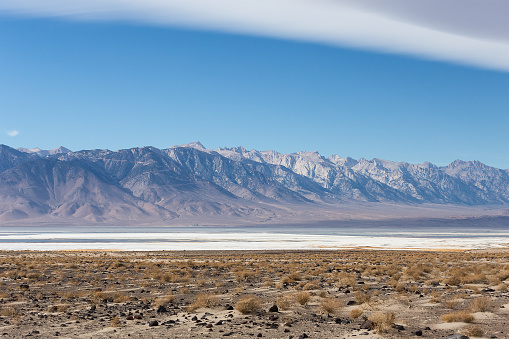 Saline Owens lake in mead of Mojave desert with Sierra Nevada mountains on background