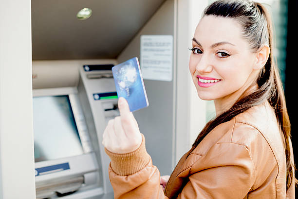 istock Young woman using a cash machine 469473754