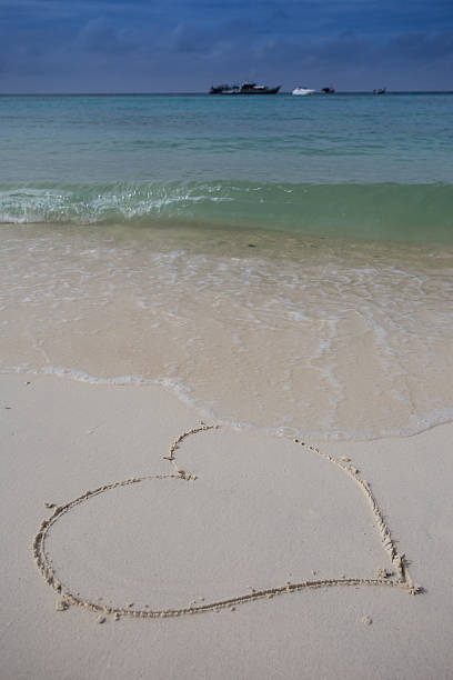 istock hearts drawn on the sand of a beach 469474442