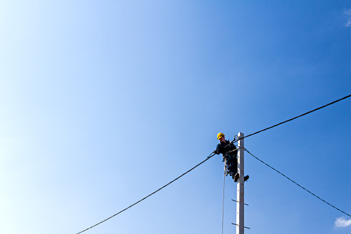 Technician works high up on a power pole