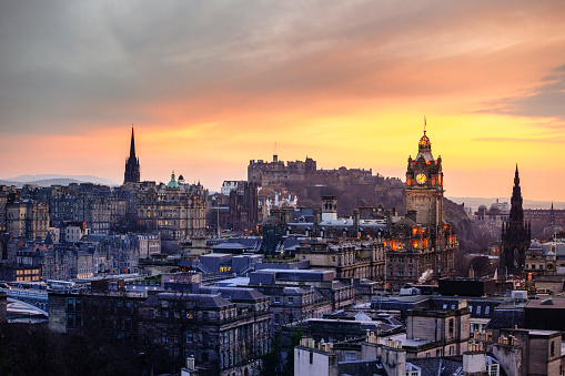 Looking over the buildings and roofs of Edinburgh Old Town towards Edinburgh Castle from Calton Hill as the sun sets.