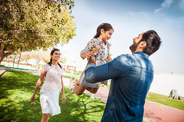 Young family enjoying life outdoor in a city park Young family enjoying life outdoor during a sunny day. The two guys spending some time together in a city park with their kid. west asian ethnicity stock pictures, royalty-free photos & images