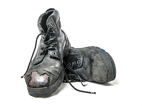 worn black safety boots on the white background