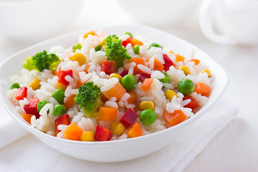 Rice with vegetables on white background