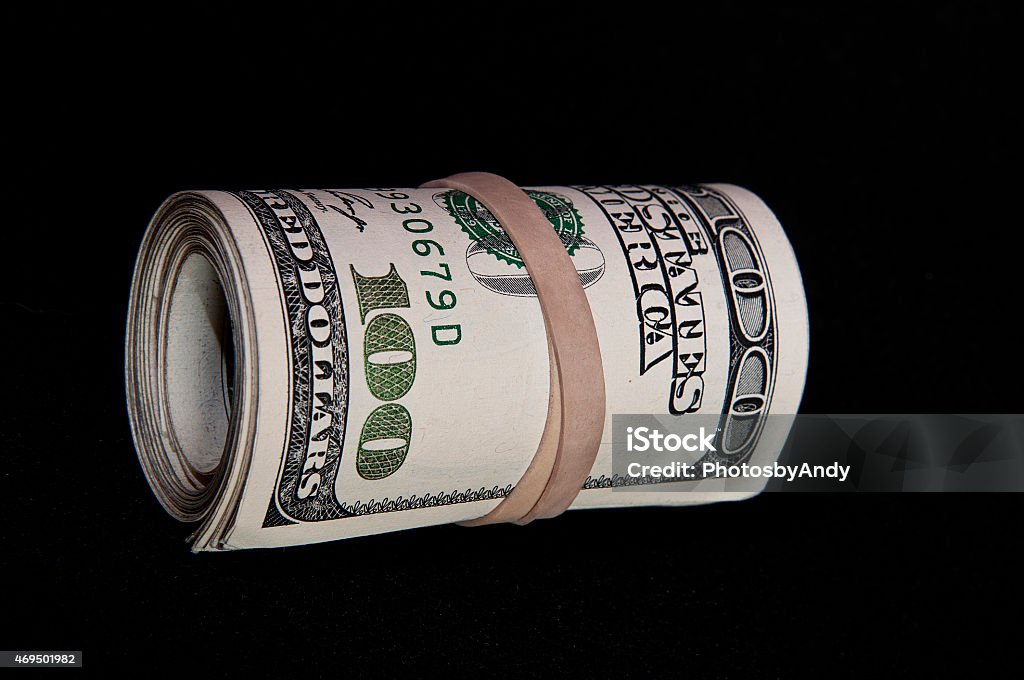 Roll of hundred dollar bills Roll of $100 bills on a black background American One Hundred Dollar Bill Stock Photo